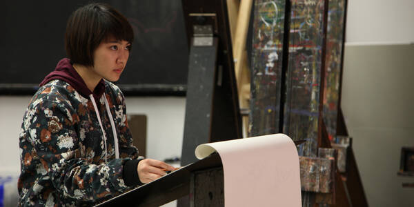 ACX Teens student sits at an easel in a drawing class