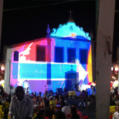 /Projection on a building in front of a crowed at night. 