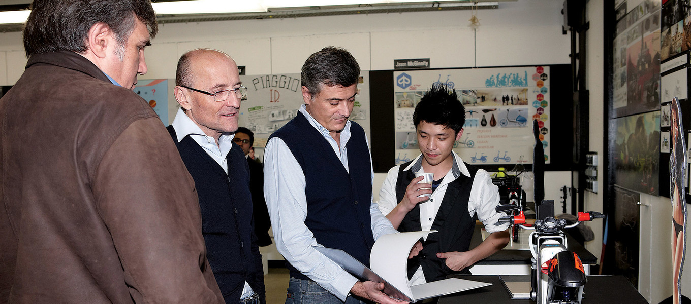 During a 2012 Piaggio sponsored project, Transportation Design alumnus Miguel Galluzzi (far left), director of Piaggio’s Advanced Design Center, discusses the concept vehicle of Product Design student Kevin Chang with colleagues Leo Mercanti, VP for product marketing, and Marco Lambri, VP for design.