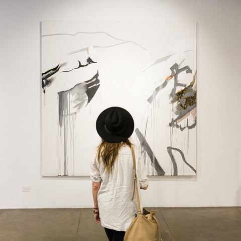 woman looking at artwork on the wall