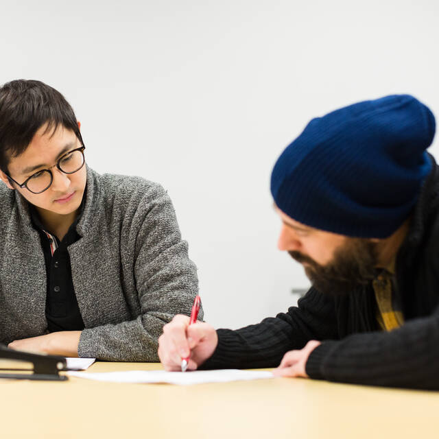 A writing center mentor works with a student to finess their writing project. 