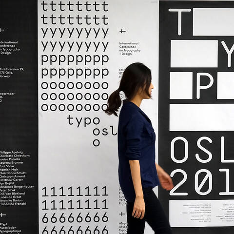 Student walking past large posters in the HMCT Gallery