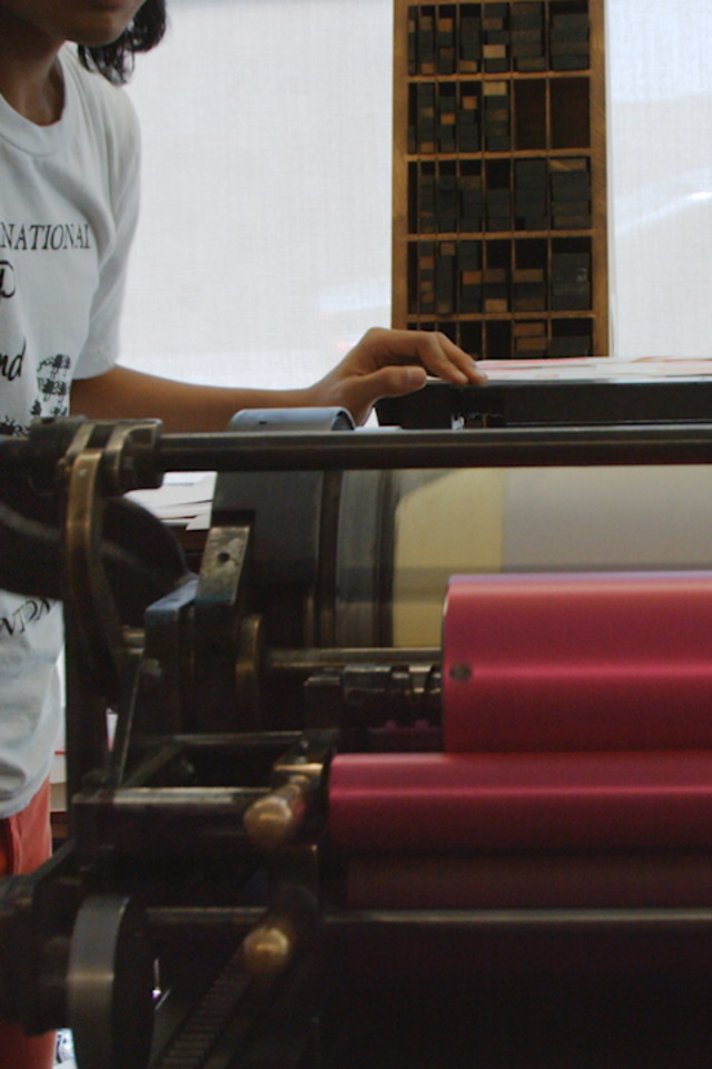 person operating a vandercook letterpress