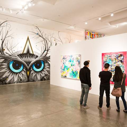 three people looking at art in gallery