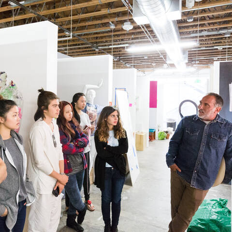 three people viewing artwork on a wall