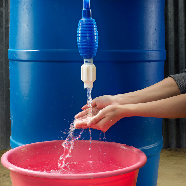 woman rinsing hands over bucket