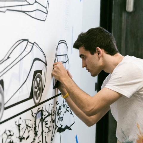 /man drawing car on wall