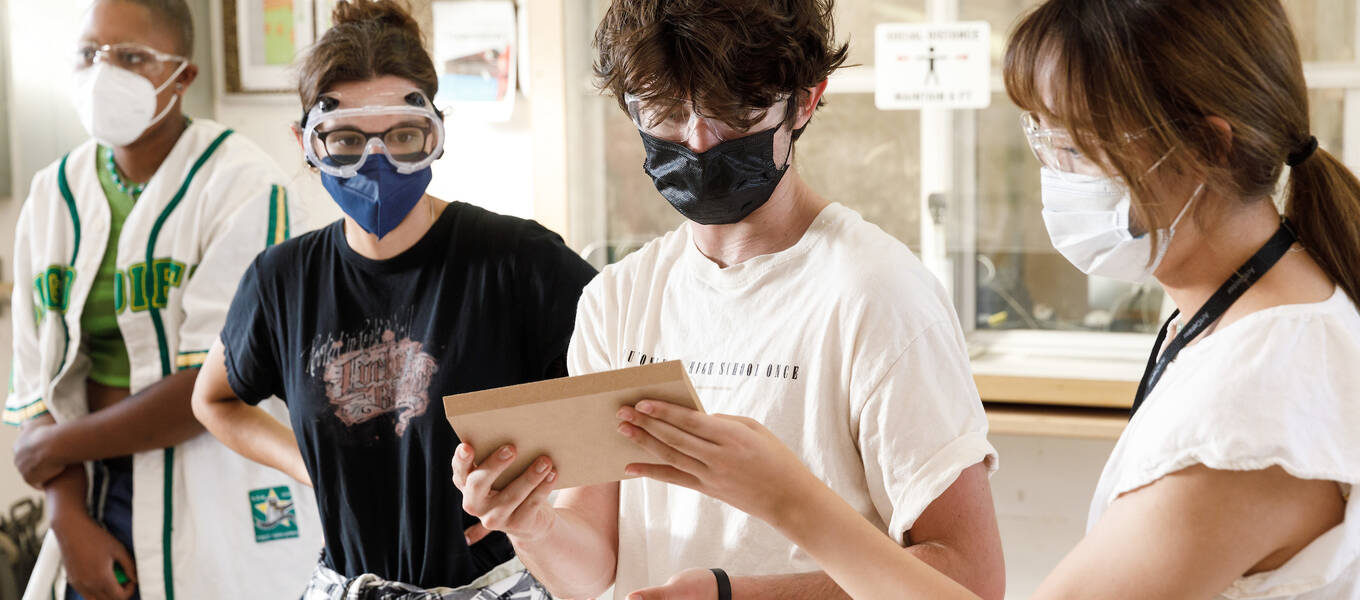 Detail of a photo of First Year Immersion student (middle) Ryan Miller with other students in the course Shop Skills Materials Lab, Fall 2022. Photo by Juan Posada.