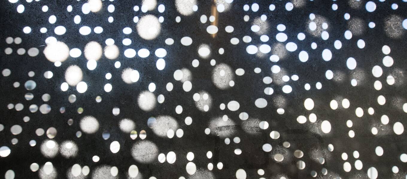 Abstract image of sunlight shining through perforated holes.