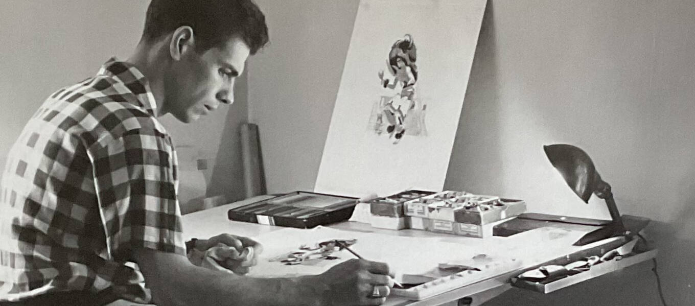 A black-and-white photo of Ross Dimond Player, wearing a checkered button-down shirt, painting at a drafting table