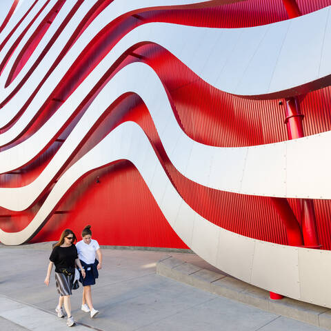 people walking under giant sculpture